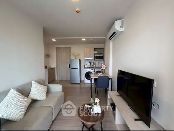 Modern living room with open kitchen, featuring sleek furniture and appliances, ideal for urban living.
