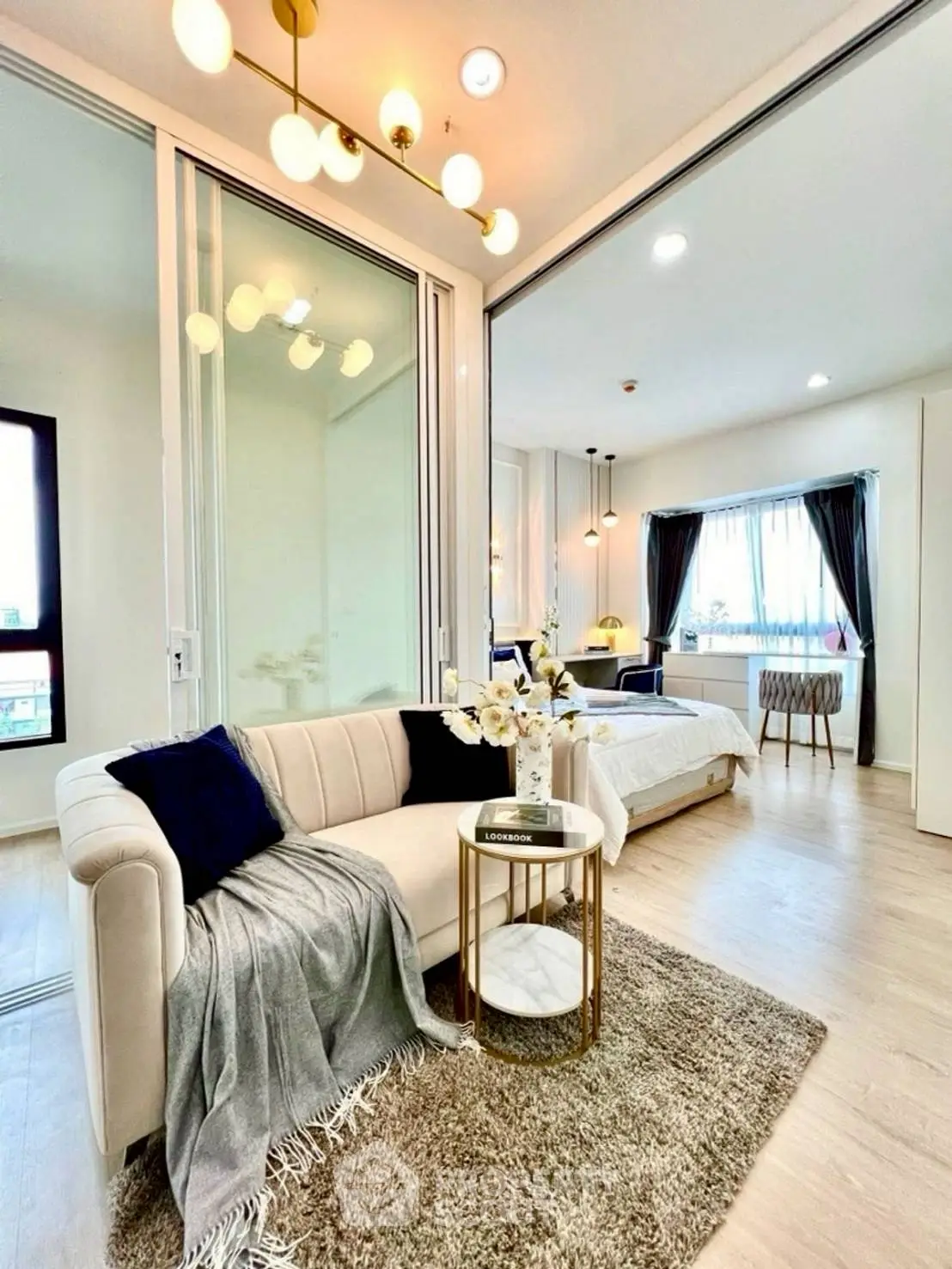 Modern open-plan living room and bedroom with elegant decor and natural light.