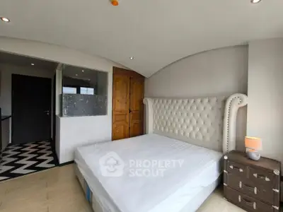 Spacious bedroom with elegant tufted headboard and modern decor