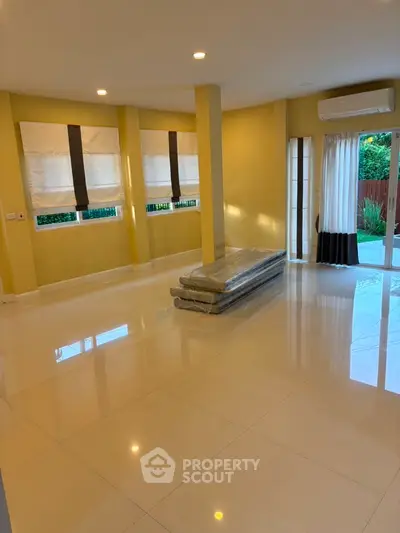 Spacious living room with large windows and modern tile flooring