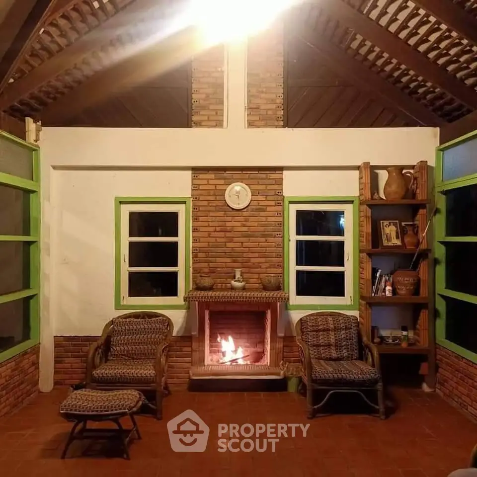 Cozy rustic living room with brick fireplace, high ceiling, and charming wicker furniture, perfect for relaxing evenings.