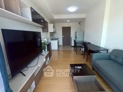Modern living room with sleek furniture and open kitchen layout in a stylish apartment.