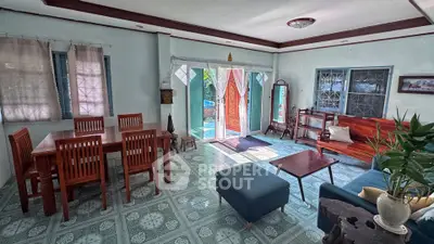 Spacious living room with elegant wooden furniture and large windows offering natural light.