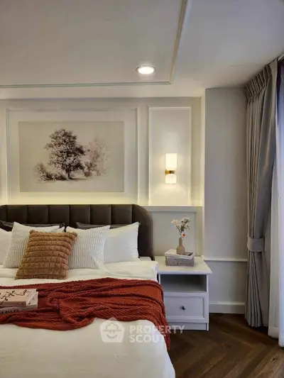 Elegant bedroom with cozy decor and stylish lighting, featuring a plush bed and warm accents.
