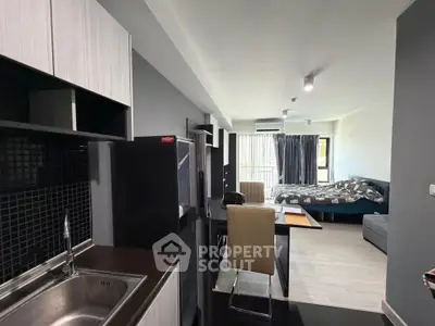 Modern studio apartment with open layout, featuring sleek kitchen and cozy living area with natural light.