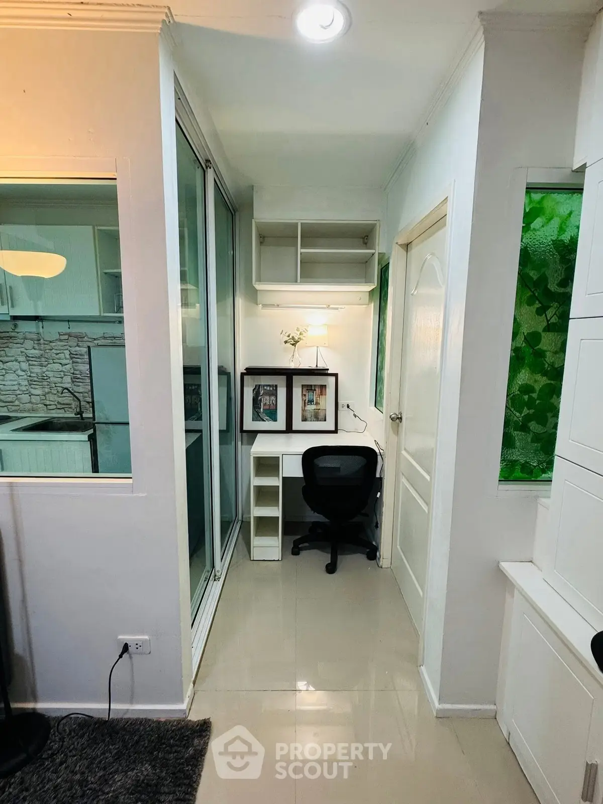 Cozy study nook with desk and chair in modern apartment, featuring sleek design and ample storage.