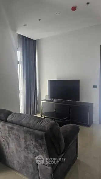 Modern living room with sleek furniture and large TV, ideal for relaxation and entertainment.