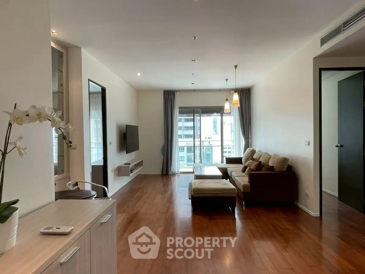 Spacious modern living room with hardwood floors and balcony view