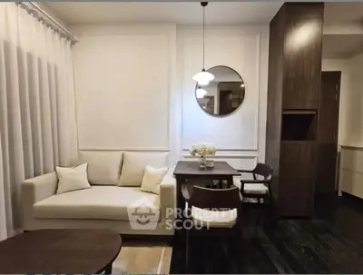 Elegant living room with modern decor, featuring a cozy sofa, stylish dining table, and chic lighting.