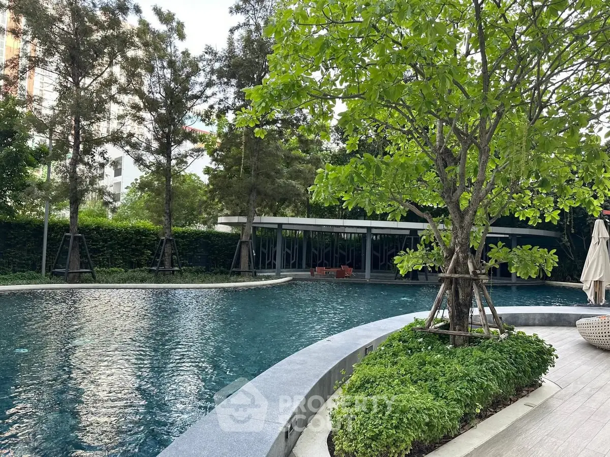 Luxurious residential pool surrounded by lush greenery and modern architecture.