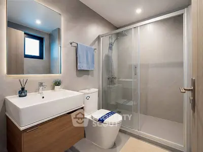 Modern bathroom with sleek design, featuring a glass shower enclosure and stylish vanity.