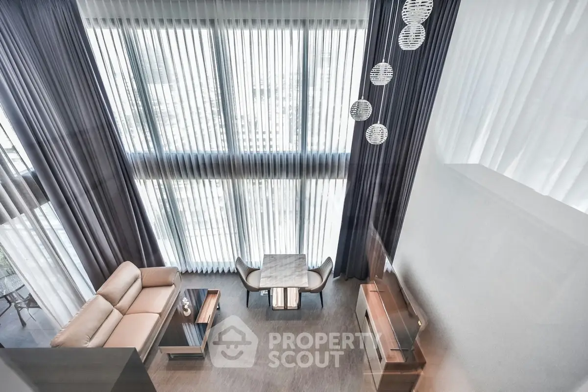Luxurious high-ceiling living room with modern decor and large windows offering abundant natural light.