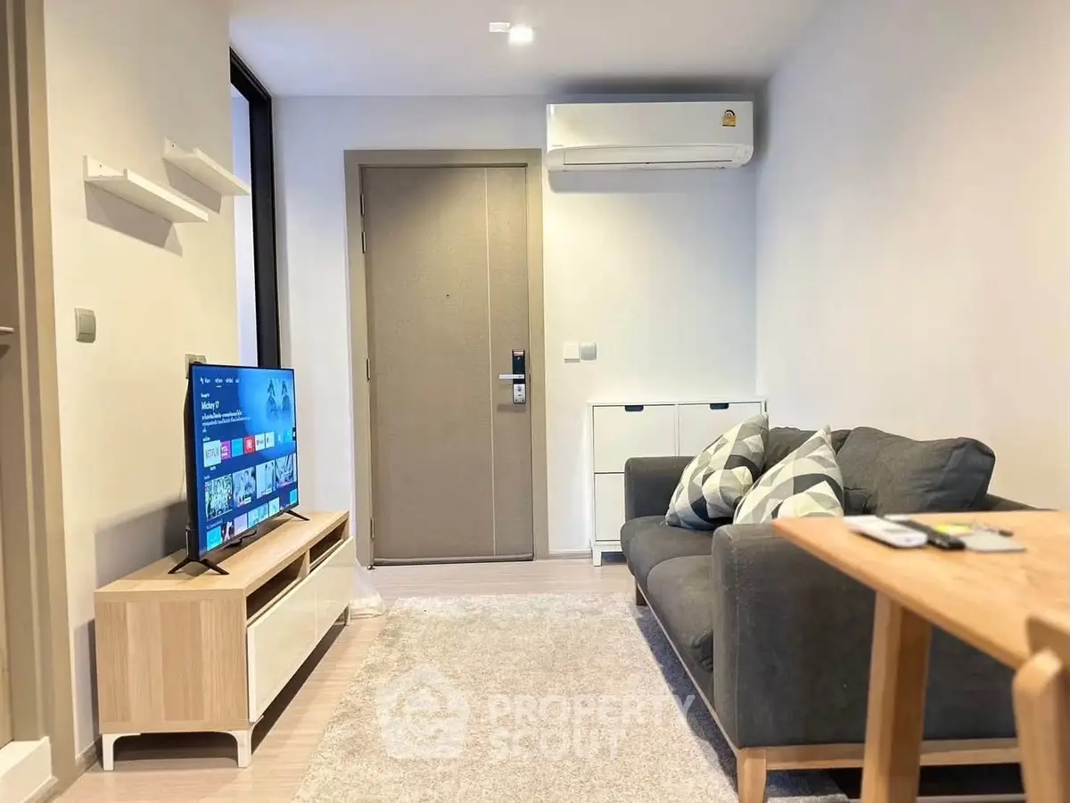 Modern living room with cozy sofa, wall-mounted TV, and air conditioning in a stylish apartment.