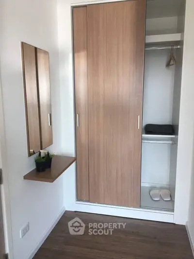 Modern minimalist bedroom with sleek wooden wardrobe and mirror