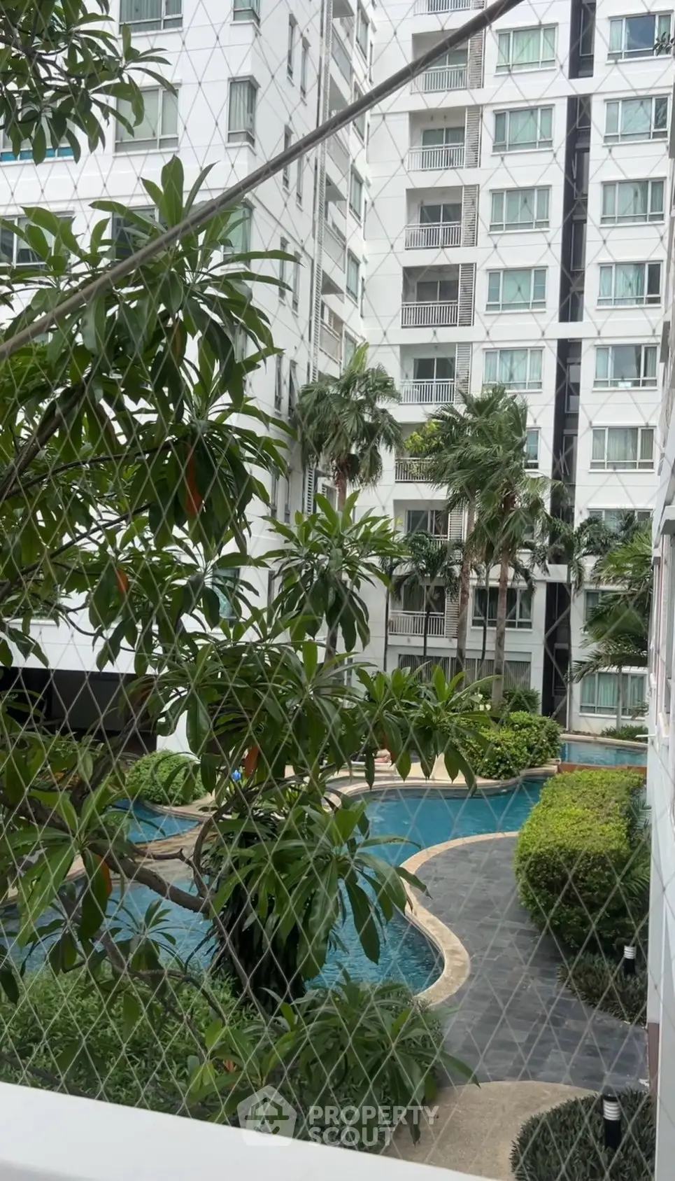 Luxurious residential building with lush garden and inviting pool view