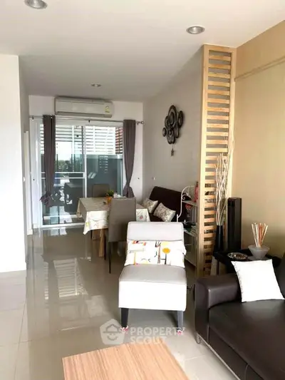 Modern living room with stylish decor and dining area, featuring sleek furniture and natural light.