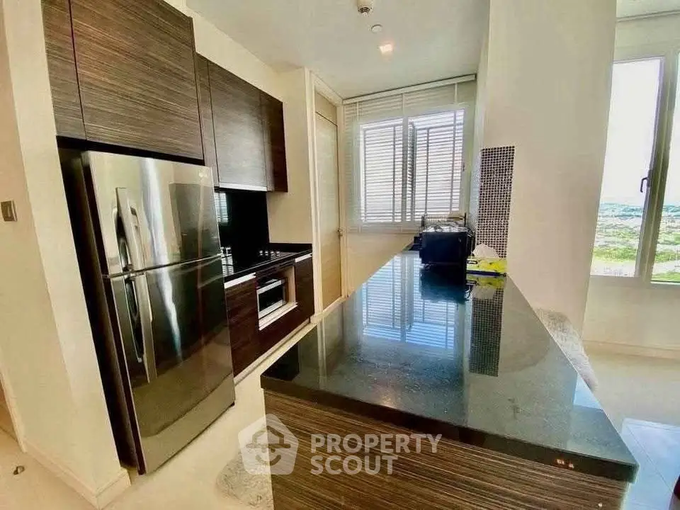 Modern kitchen with sleek cabinetry and stainless steel appliances in a bright apartment.
