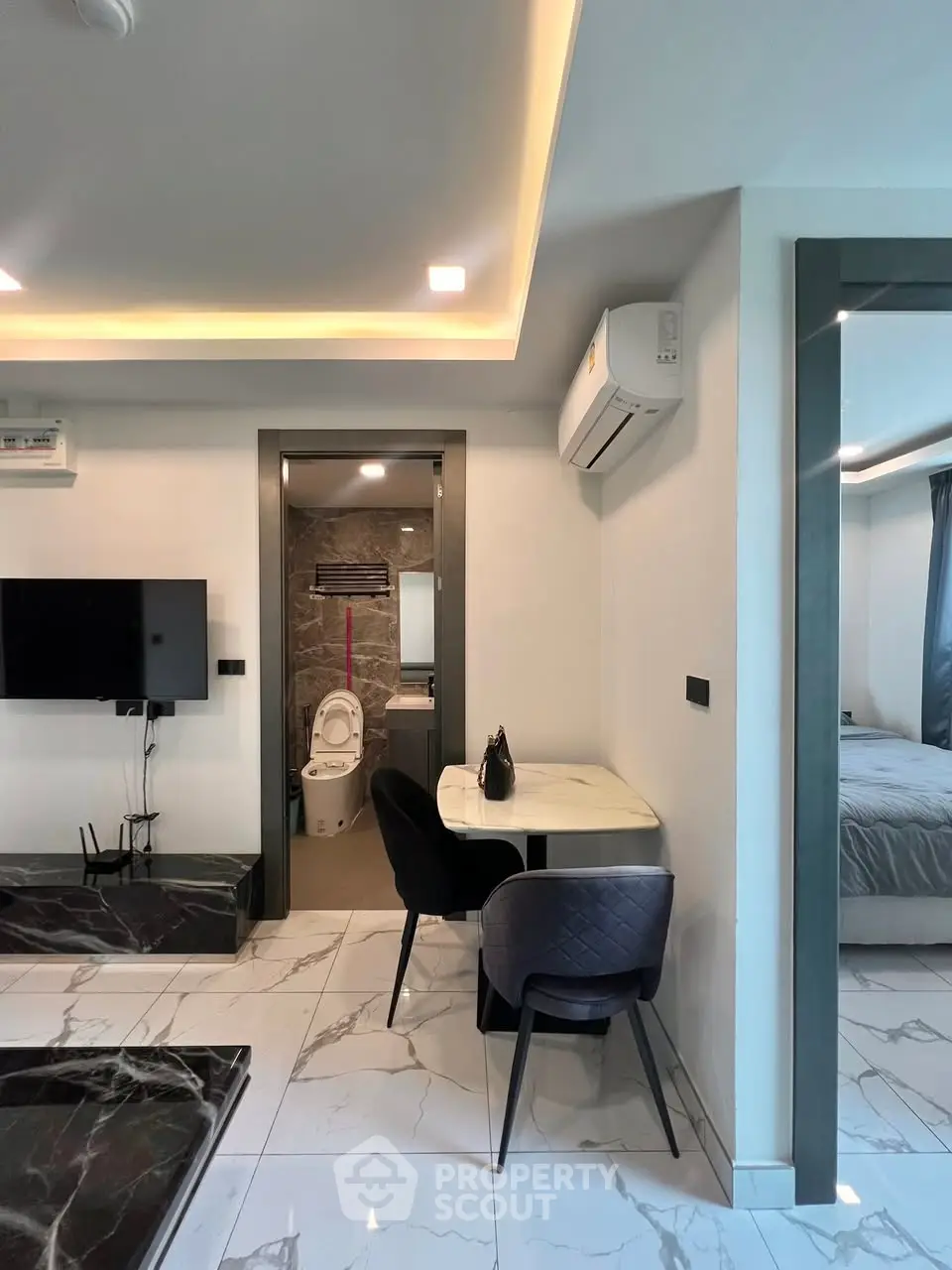 Modern apartment interior with open living area and visible bathroom