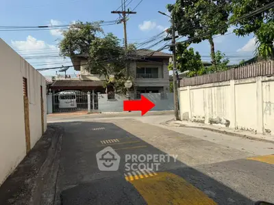 Charming suburban house with gated entrance and lush greenery, perfect for family living.