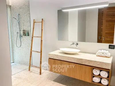 Modern bathroom with elegant wooden vanity and spacious walk-in shower