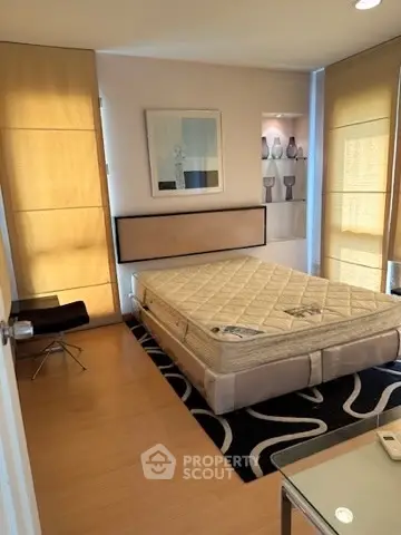Modern bedroom with stylish decor and natural light, featuring a comfortable bed and elegant furnishings.