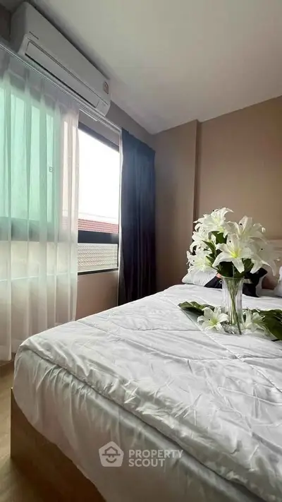 Cozy bedroom with elegant decor and natural light, featuring a stylish air conditioner.