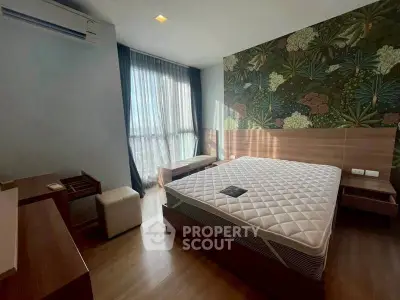 Spacious bedroom with modern decor and large window offering natural light.