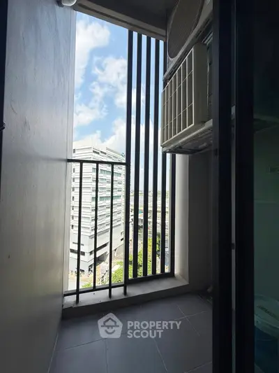 Modern apartment balcony with city view and air conditioning unit.