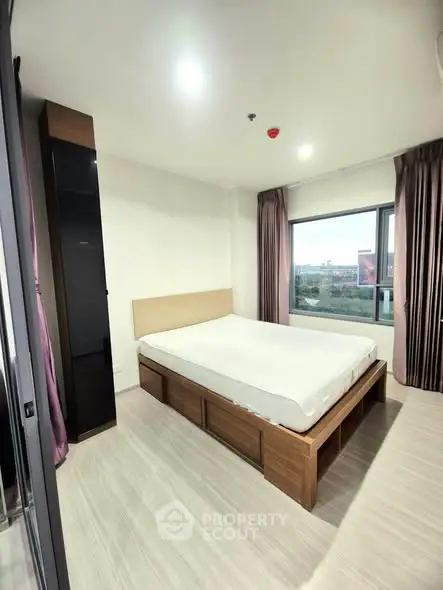 Modern bedroom with large window and wooden flooring