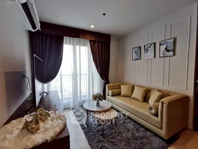 Elegant living room with plush sofa, stylish decor, and large window for natural light.