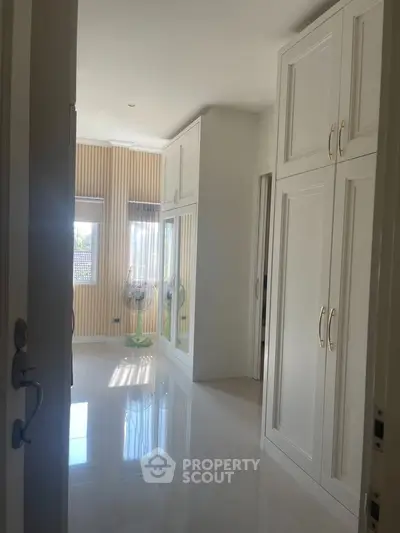 Spacious bedroom with elegant built-in wardrobes and natural light
