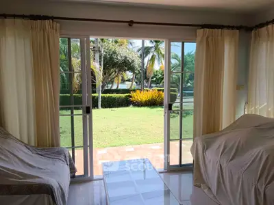 Bright living room with sliding glass doors opening to lush garden view.