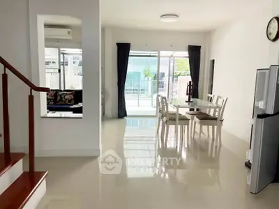 Spacious modern living area with dining set and balcony view, featuring sleek flooring and natural light.