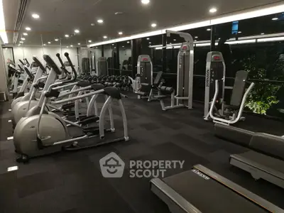 Modern gym with state-of-the-art fitness equipment and large mirrors in a residential building.