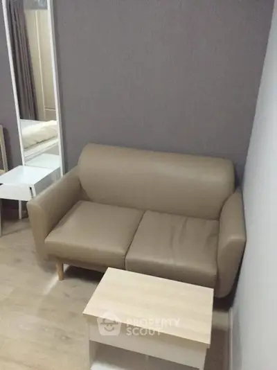 Cozy small living room with beige sofa and wooden coffee table