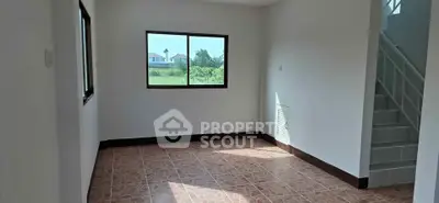 Spacious unfurnished room with tiled floor and large window offering scenic views.