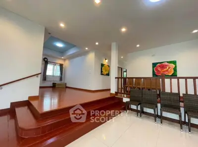 Spacious living area with wooden flooring and modern lighting, perfect for family gatherings.