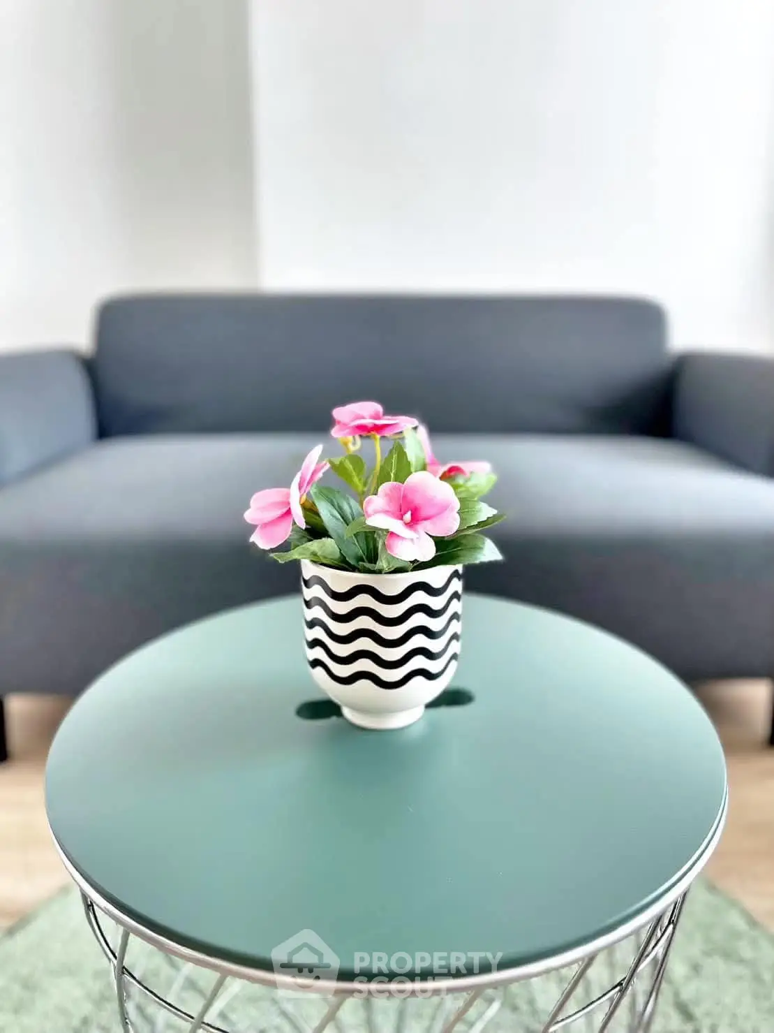 Stylish living room with modern sofa and chic coffee table featuring a decorative flower pot.