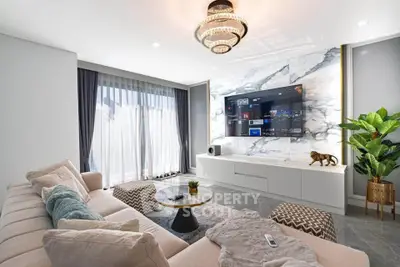 Luxurious modern living room with elegant decor, marble wall, and large TV, perfect for relaxation and entertainment.