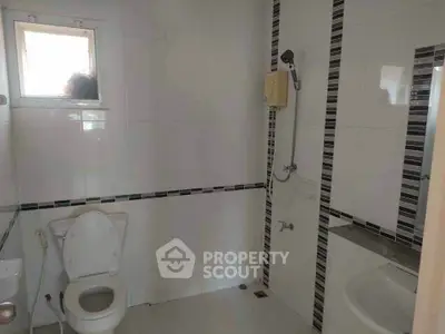 Modern bathroom with sleek white tiles and a shower area