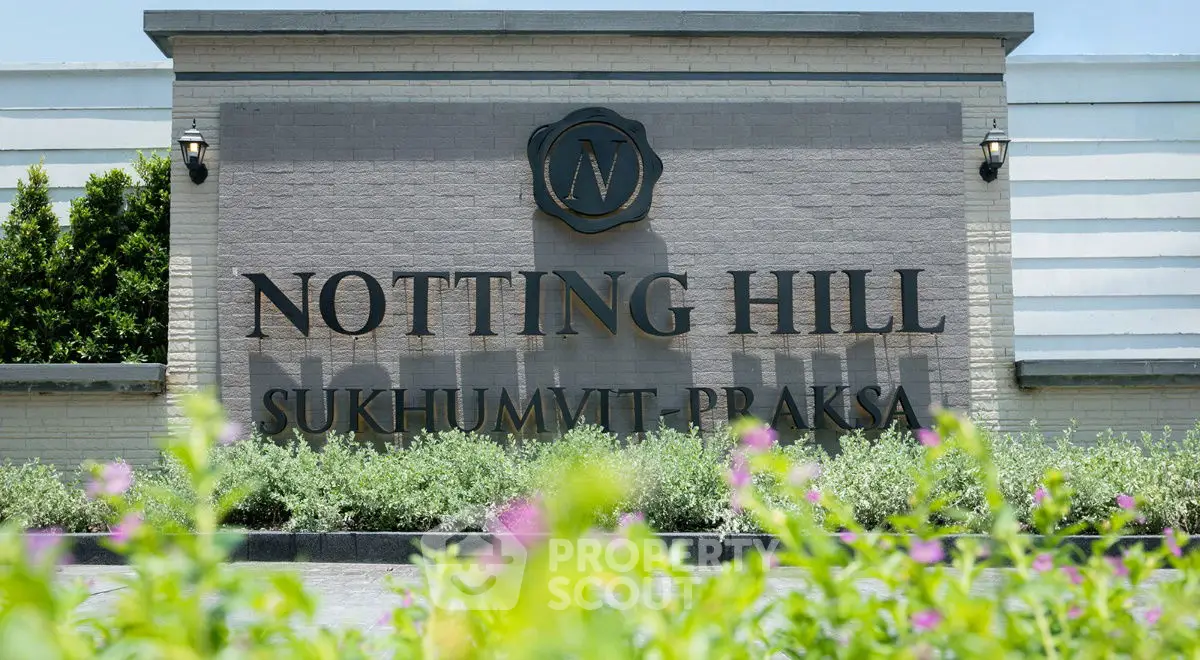 Elegant entrance sign of Notting Hill Sukhumvit Praksa surrounded by lush greenery.
