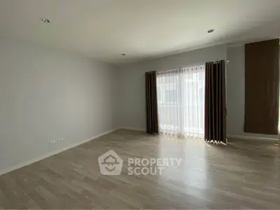 Spacious empty room with large window and elegant curtains, perfect for customization.