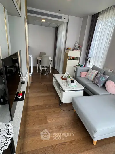 Modern living room with sleek furniture and wooden flooring in a cozy apartment setting.