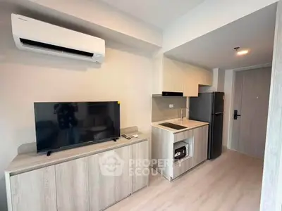Modern compact kitchen with sleek appliances and stylish cabinetry in a cozy apartment.