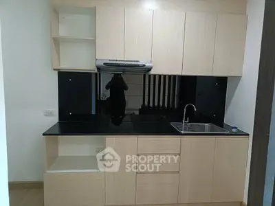 Modern kitchen with sleek black countertops and light wood cabinets