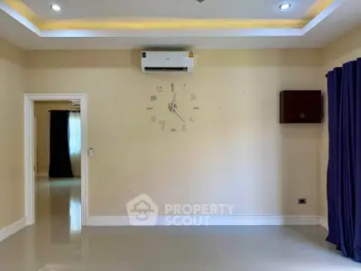 Spacious living room with modern air conditioning and stylish wall clock, ideal for comfortable living.