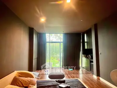 Spacious modern living room with large window and garden view, featuring sleek design and cozy ambiance.