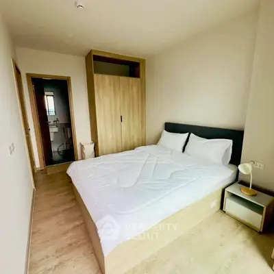 Modern bedroom with cozy bed and built-in wardrobe in a minimalist apartment.