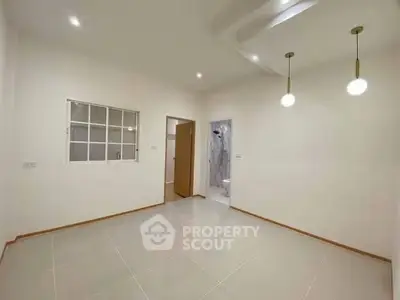 Spacious minimalist living room with modern lighting and tiled flooring