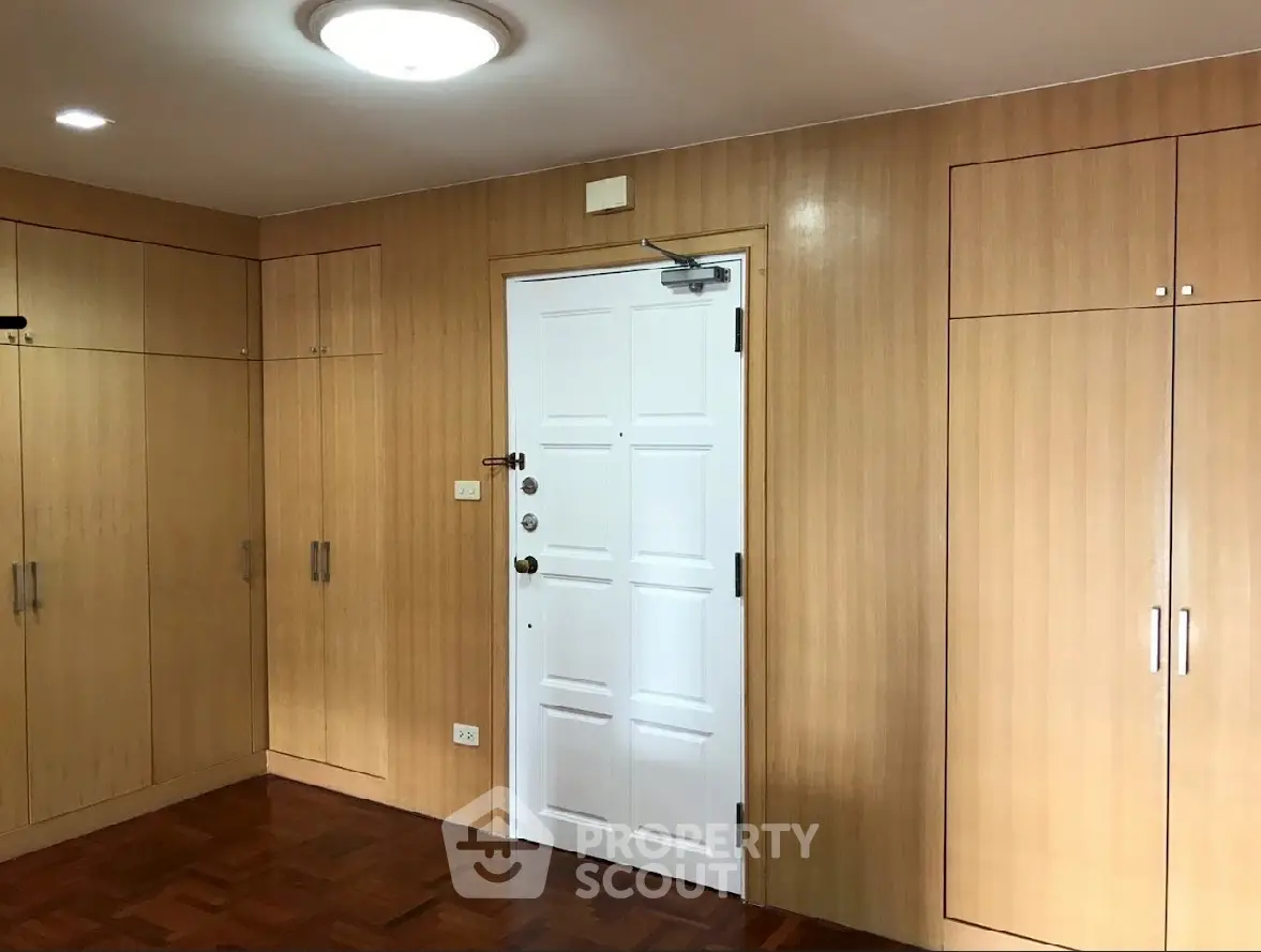 Spacious room with wooden built-in closets and secure white door